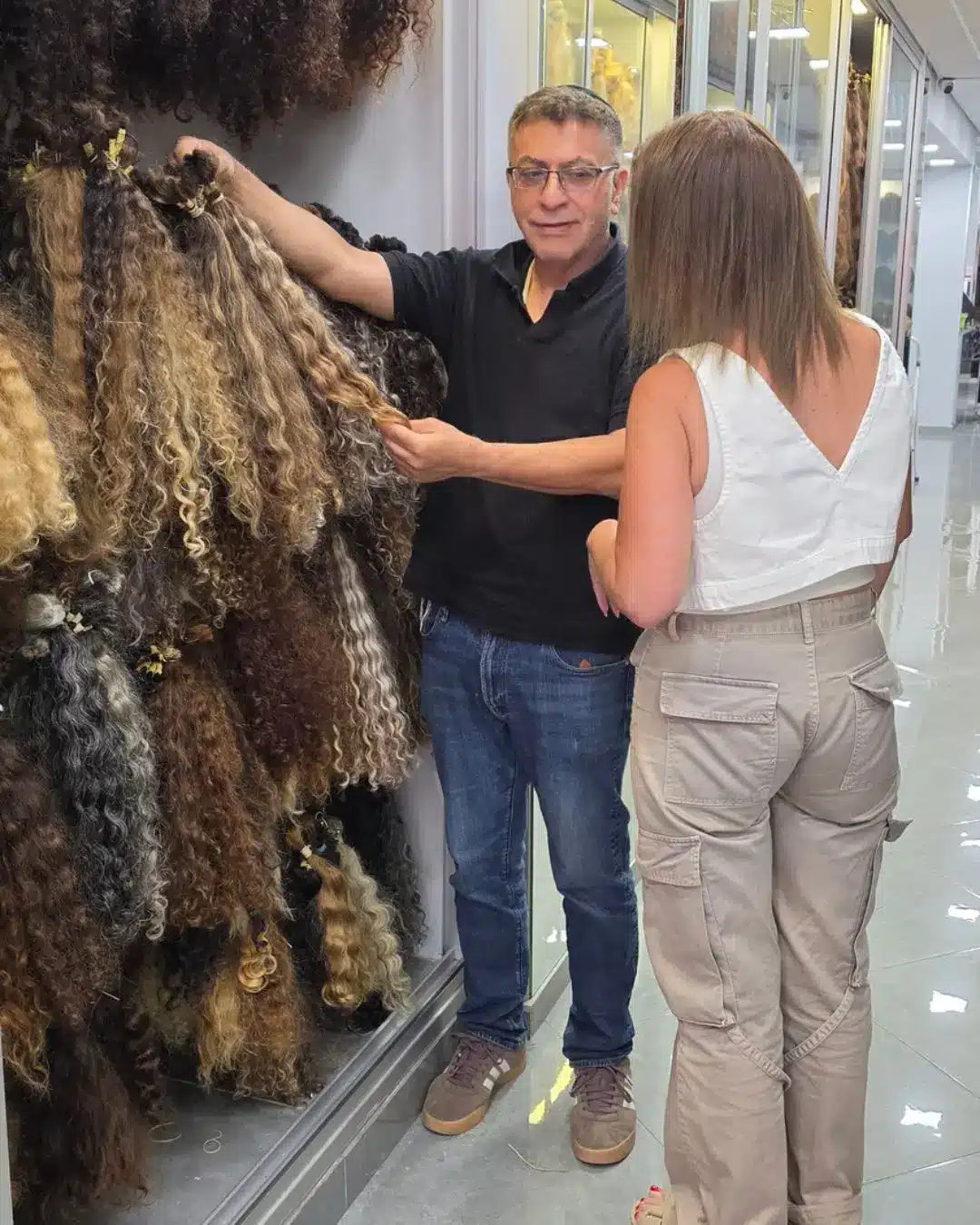 מוטי רונאל והלקוחה תוך כדי בחירת השיער מתוך המלאי האדיר של שיער טבעי בתולי שנמצא אצלנו בתצוגה
