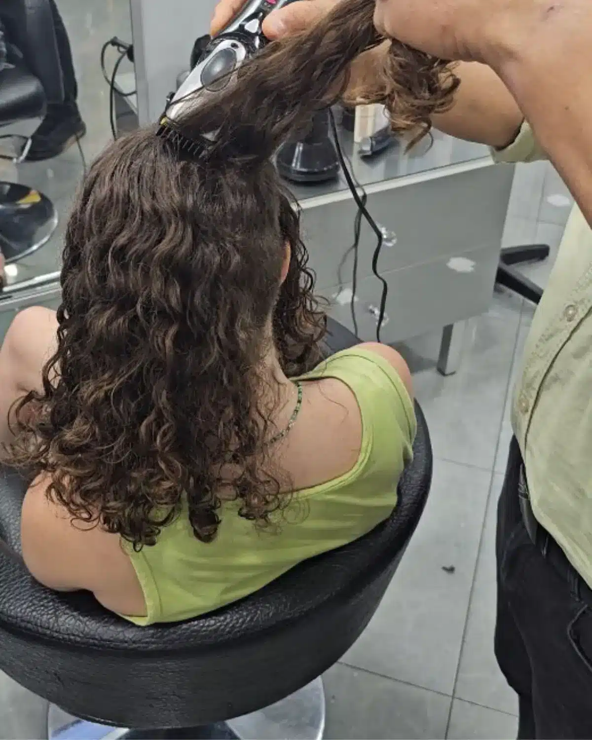 גזירת השיער המתולתל לפני איסופו לקוקו