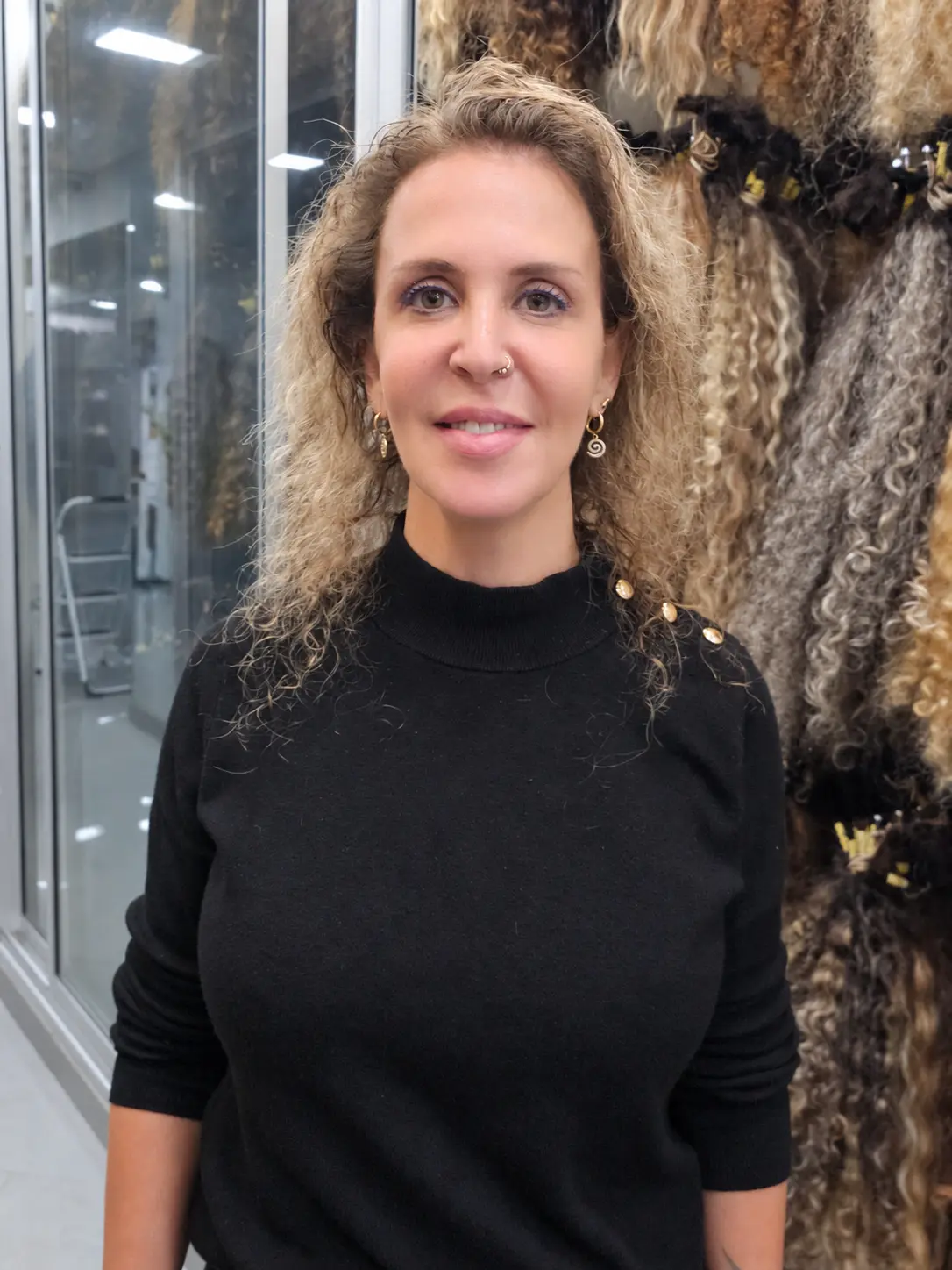 תוספות שיער לתלתלים לפני: לקוחה אמיתית עם תלתלים בלונד כהה עד הכתפיים, לא צפופים, מול תצוגת שיער מתולתל בסטודיו